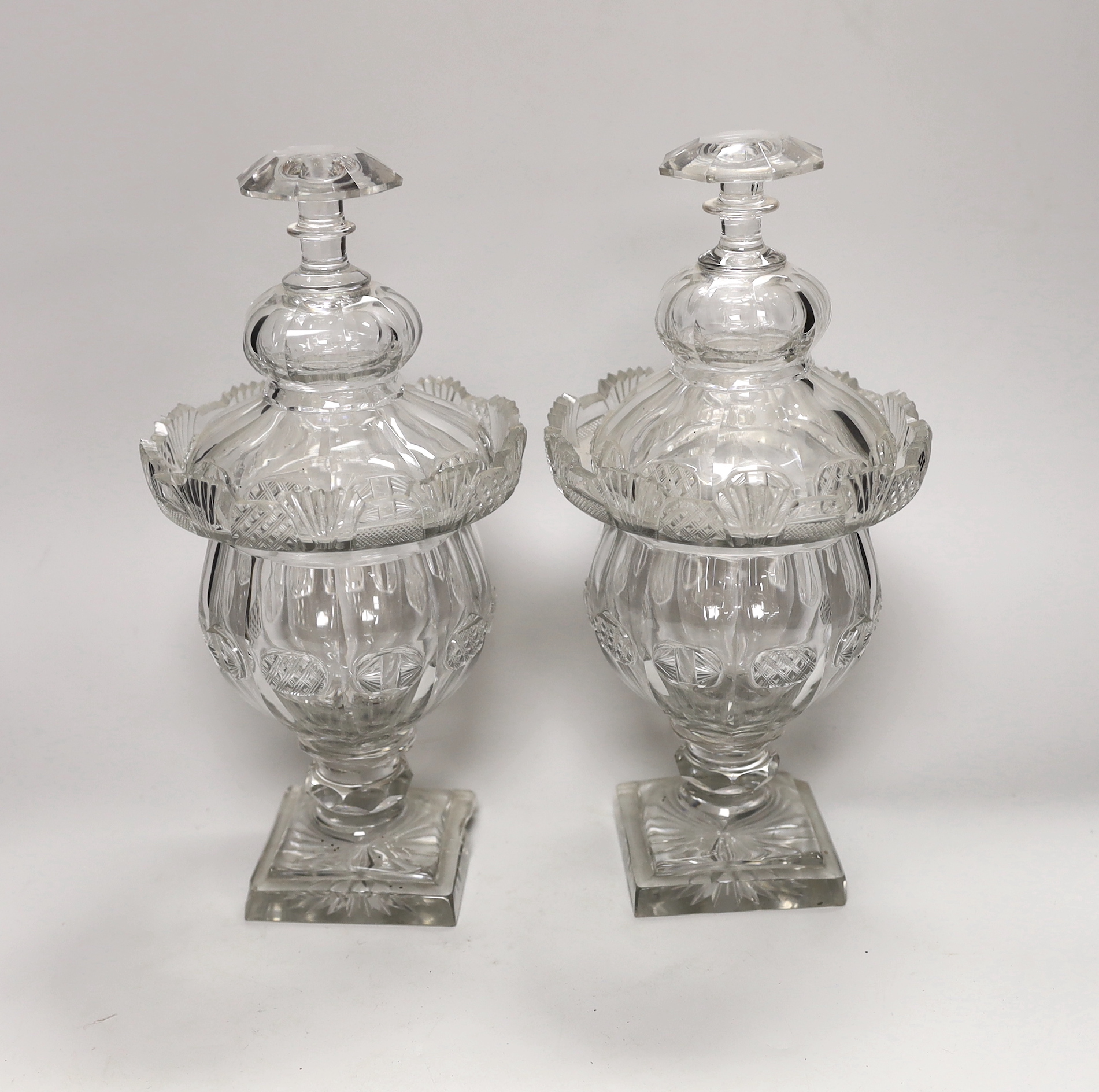 A pair of early Victorian cut glass pomade jars and covers, 30cm